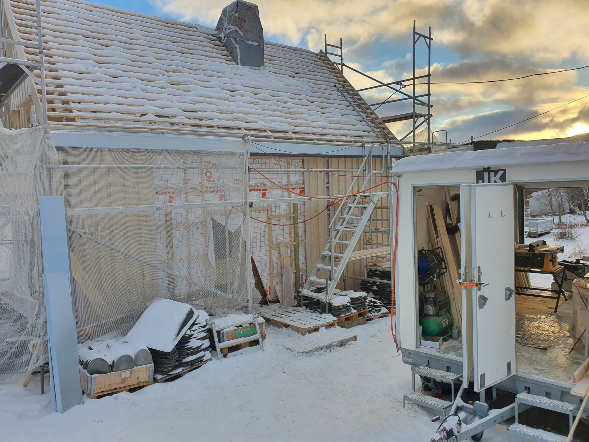 Eldre hus med stillas under rehabilitering om vinteren